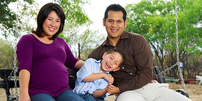 Familia sonriente en el banco del parque